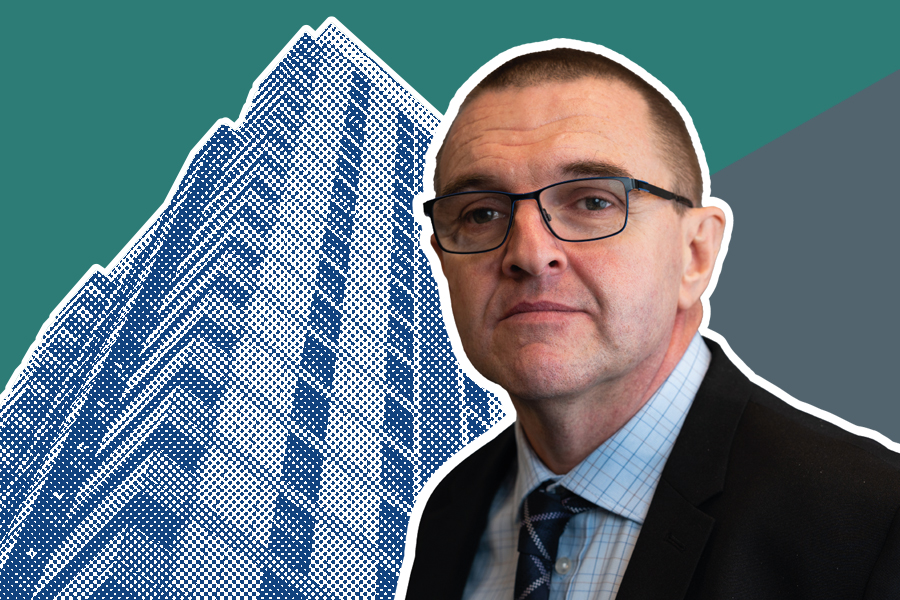 Andrew Saunders in front of a blue high-rise building in a halftone pattern