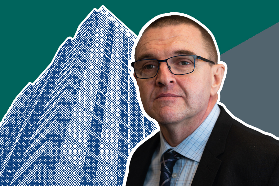 Andrew Saunders in front of a blue high-rise building in a halftone pattern