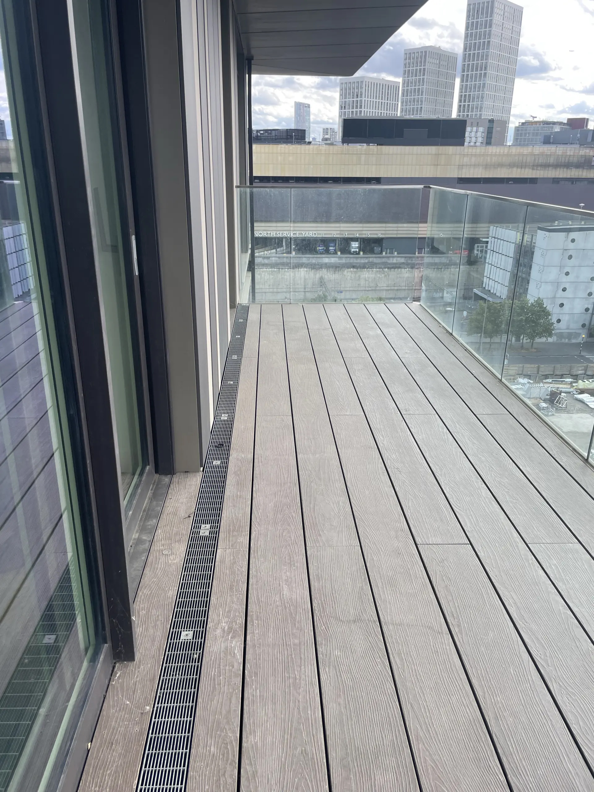 A view of a balcony floor with tall buildings in the background
